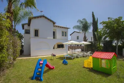 a yard with childrens play equipment in front of a house at Konnos Blue in Protaras