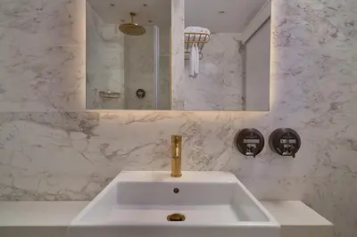 a bathroom with a white sink and a mirror at Hotel Napa Suites (Adults Only) in Ayia Napa