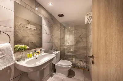 a white bathroom with a sink and a toilet at Milea Hotel in Ayia Napa