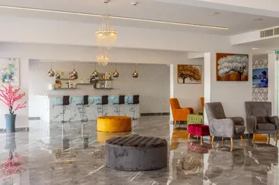 a lobby with a bar with chairs and a table at Milea Hotel in Ayia Napa