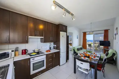a kitchen with a table and a dining room at Green Bay Penthouse 2 in Protaras