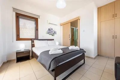 a bedroom with a bed with towels on it at Villa Iris by Ezoria Villas in Ayia Napa