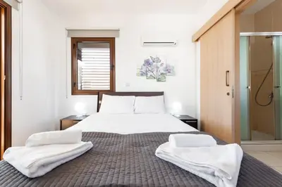 a bedroom with a bed with two towels on it at Villa Iris by Ezoria Villas in Ayia Napa
