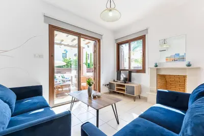 a living room with blue couches and a table at Villa Iris by Ezoria Villas in Ayia Napa