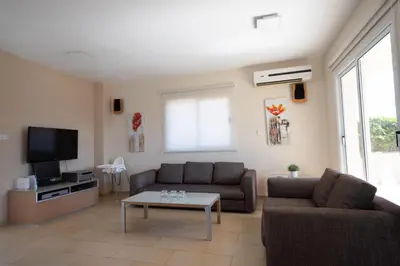a living room with two couches and a tv at Athena Villa in Ayia Napa