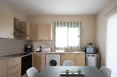 a kitchen with a table and a sink and a dishwasher at Athena Villa in Ayia Napa