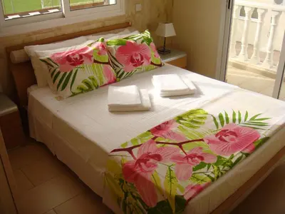 a bedroom with a bed with a flower patterned blanket at Athena Villa in Ayia Napa