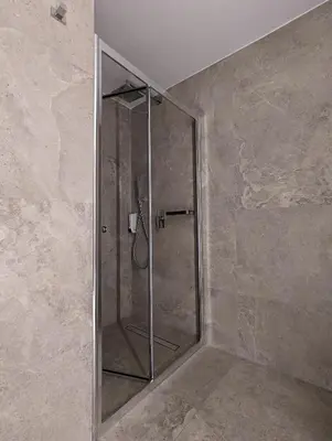 a shower with a glass door in a bathroom at Tuck Inn in Larnaka