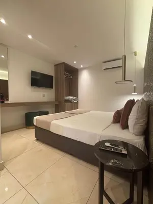 a bedroom with a bed with a table and a tv at Tuck Inn in Larnaka