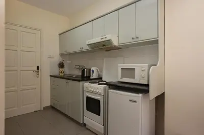 a kitchen with white cabinets and a white stove top oven at Sunquest Gardens Holiday Resort in Limassol
