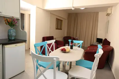 a kitchen and a table and chairs in a room at Sunquest Gardens Holiday Resort in Limassol