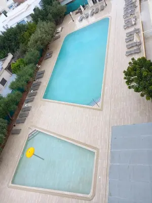 an overhead view of a swimming pool with a yellow ball at Sunquest Gardens Holiday Resort in Limassol