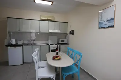 a kitchen with a table and chairs with a bottle of wine at Sunquest Gardens Holiday Resort in Limassol