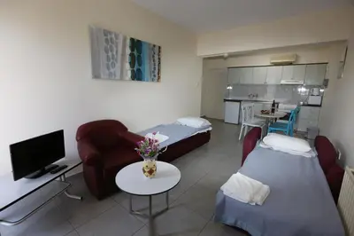 a living room with two beds and a couch and a tv at Sunquest Gardens Holiday Resort in Limassol