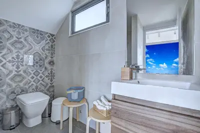 a bathroom with a toilet and a sink and a window at White Pearl Villas in Protaras