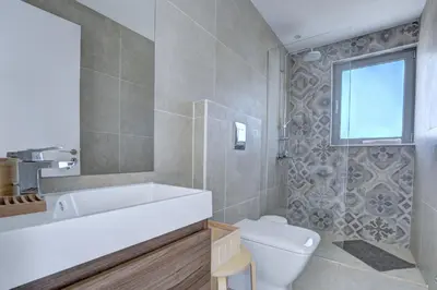 a bathroom with a tub and a toilet and a sink at White Pearl Villas in Protaras