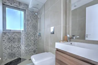 a bathroom with a toilet and a sink and a mirror at White Pearl Villas in Protaras