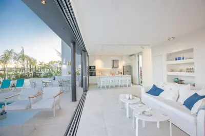 a living room with a white couch and tables at White Pearl Villas in Protaras