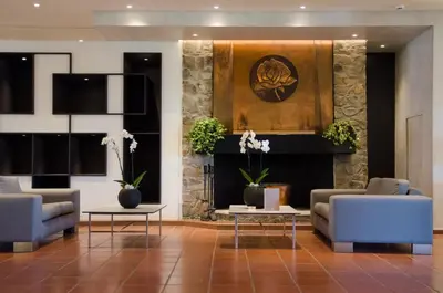 a lobby with two couches and a fireplace at Rodon Hotel and Resort in Agros