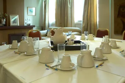 a table with white dishes and pitchers on top of it at Cleopatra Hotel in Nicosia