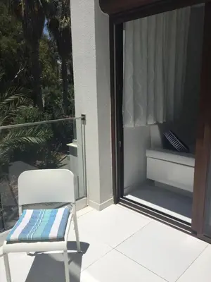 a white chair sitting on a balcony with a window at Modern Seaview Beach Studio Limassol in Limassol