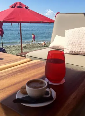 a cup of coffee on a table at the beach at Modern Seaview Beach Studio Limassol in Limassol