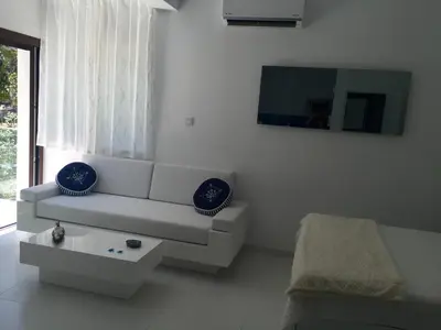 a white living room with a couch and a table at Modern Seaview Beach Studio Limassol in Limassol