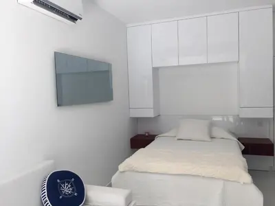 a white bedroom with a bed and white cabinets at Modern Seaview Beach Studio Limassol in Limassol