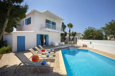 a villa with a swimming pool in front of a house at Villa Serene in Ayia Napa