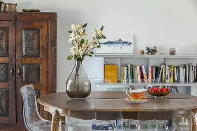 a vase with flowers on a table with a cup of coffee at Villa Serene in Ayia Napa