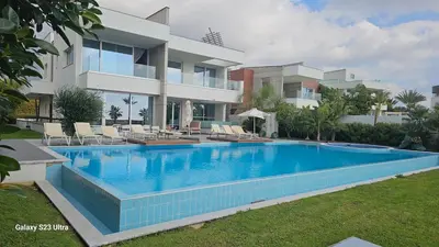 a swimming pool in front of a building at Beachfront Luxury Villa Tranquility in Ayia Napa