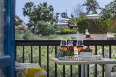 two glasses of wine sitting on a table on a balcony at Protaras Ayios Elias Suite in Protaras
