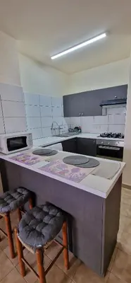a kitchen with a counter with two stools in it at Serenity by the sea in Larnaka