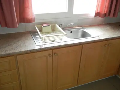 a kitchen counter with a sink and a window at Tsialis Hotel Apartments in Larnaka