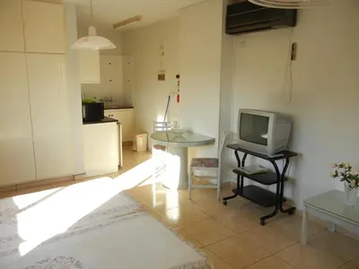 a living room with a tv and a table at Tsialis Hotel Apartments in Larnaka