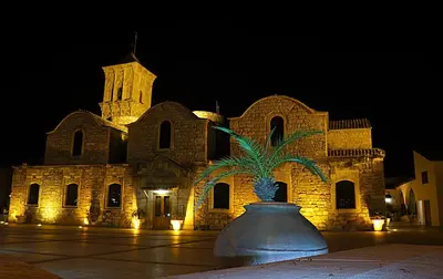 a large building with a palm tree in front of it at Onisillos Hotel in Larnaka