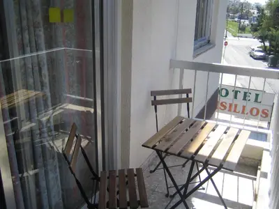 a wooden table and two chairs on a balcony at Onisillos Hotel in Larnaka