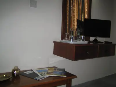 a room with a table with a tv on a wall at Onisillos Hotel in Larnaka