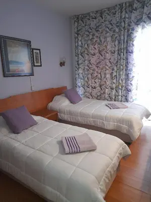 two beds in a hotel room with a window at Onisillos Hotel in Larnaka