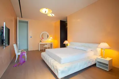 a bedroom with a large white bed and a mirror at Olympic Residence Deluxe Apartments in Limassol