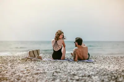a man and a woman sitting on a beach at Lebay Beach Hotel in Larnaka