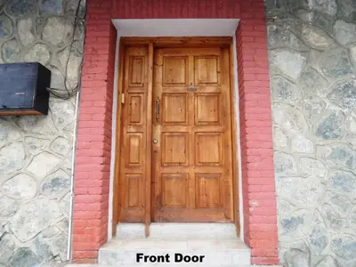 a wooden door on a stone building with the words front door at Metaxas Mansion in Kakopetria