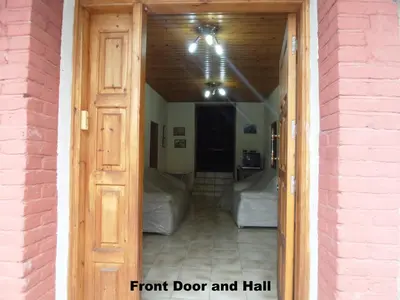 an open door to a room with a front door and hall at Metaxas Mansion in Kakopetria