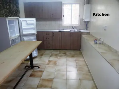 a kitchen with wooden cabinets and a table in it at Metaxas Mansion in Kakopetria