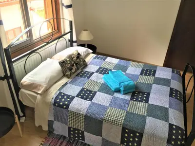 a bedroom with a bed with a checkered blanket at Gold Mountain House in Moutoullas