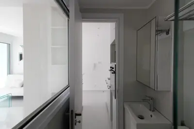 a white bathroom with a sink and a toilet at The White Pearl Suite - beach front city centre with sea view. in Limassol