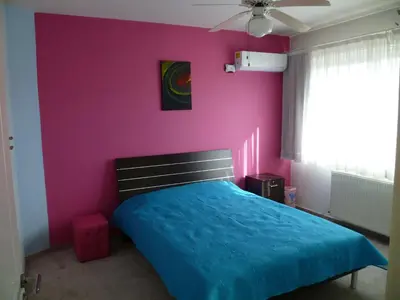 a bedroom with a blue bed and a pink wall at Double room with ensuite bathroom at Datacom building in Nicosia