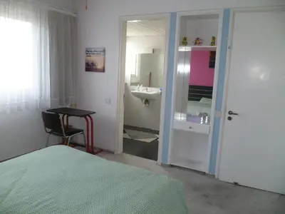 a bedroom with a bed and a bathroom with a sink at Double room with ensuite bathroom at Datacom building in Nicosia