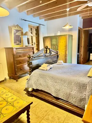 a bedroom with a large bed and a dresser at Cornaro House in Arsos