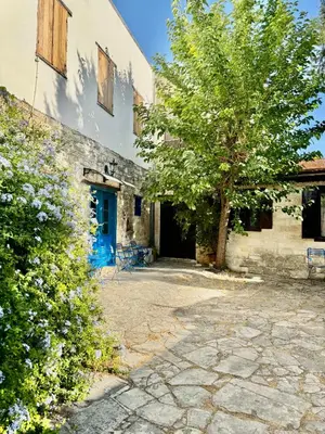 a building with a blue door and a tree at Cornaro House in Arsos